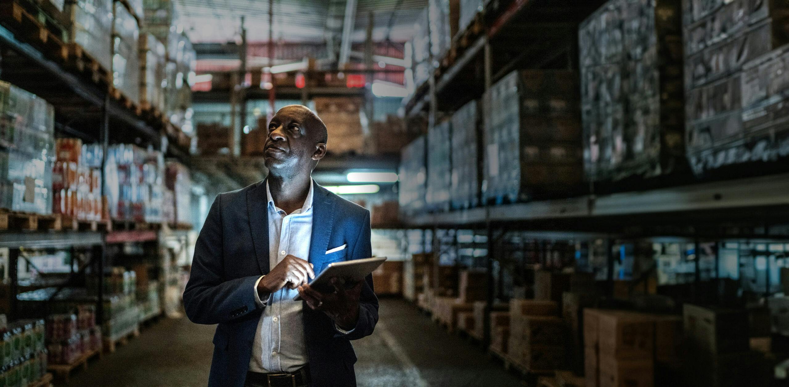 Mature man using the digital tablet in a warehouse